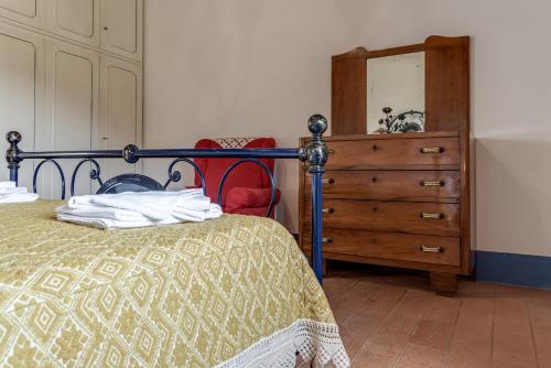 a bedroom with a bed and a dresser and a mirror at La Casa di Colle in Dicomano