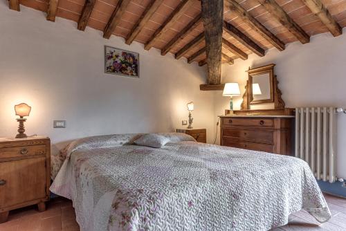 a bedroom with a bed and two dressers and a mirror at La Casa di Colle in Dicomano