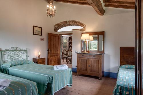 a bedroom with two beds and a mirror at La Casa di Colle in Dicomano