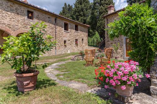 a garden with chairs and flowers in front of a building at La Casa di Colle in Dicomano