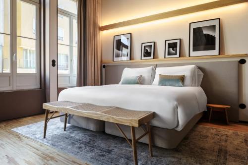 a bedroom with a large white bed and a table at Feel Porto Matosinhos City Flats in Matosinhos