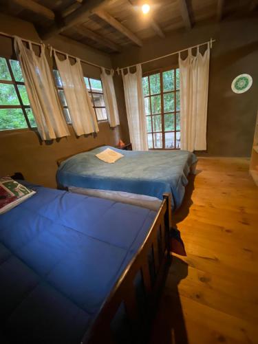 1 Schlafzimmer mit 2 Betten in einem Zimmer mit Fenstern in der Unterkunft Eco cabaña Tierra Fértil in Santa Ana