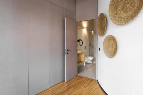 a room with a bathroom with a toilet and a door at Feel Porto Matosinhos City Flats in Matosinhos