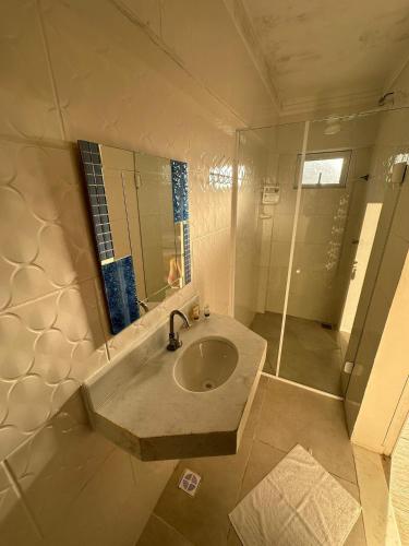 a bathroom with a sink and a shower at Mansão Tenório in Ubatuba