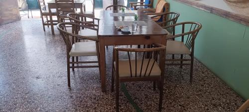 a wooden table and chairs in a restaurant at Hotel zakros rooms-restaurant in Zákros