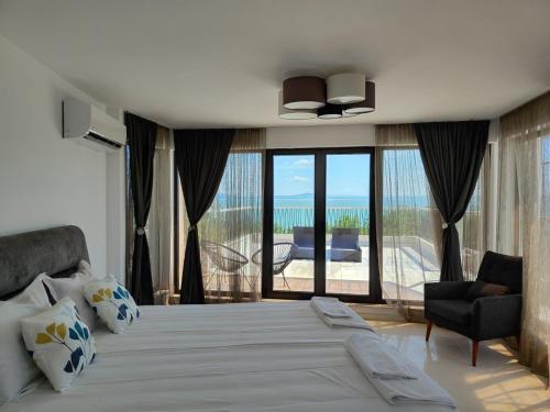 sypialnia z dużym łóżkiem i widokiem na ocean w obiekcie Marina Sarafovo w Burgas