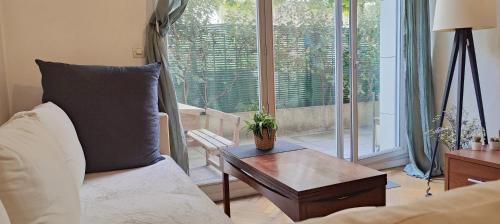un salon avec un canapé et une table dans l'établissement Your lovely parisian 2 rooms apartment with private terrace - Jourdain, à Paris