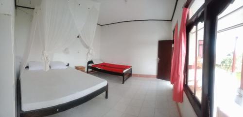 a room with two beds and a chair in it at Volcano 3 hotel in Kintamani