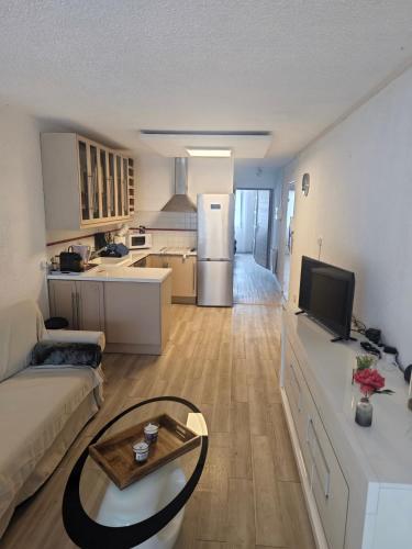 un salon avec un canapé et une table et une cuisine dans l'établissement Valentinvtc location, au Cap d'Agde