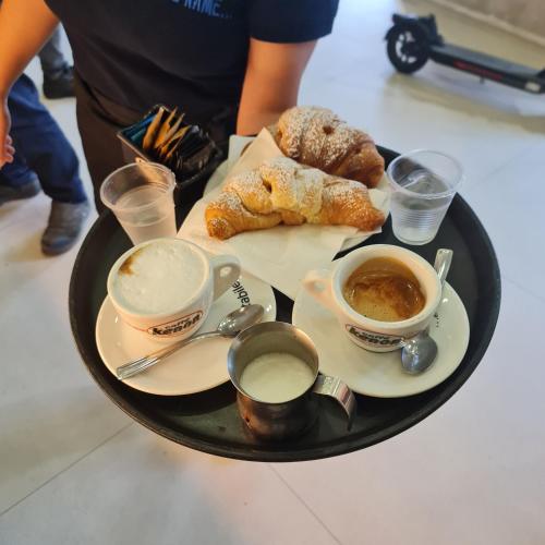 a tray of food with cups of coffee and pastries at Mare Fuori B&B in Salerno