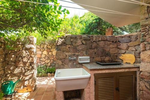 a bathroom with a sink and a stone wall at Villa Gabbiani in Vignola Mare