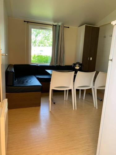 un salon avec un canapé, une table et des chaises dans l'établissement Camping Marvilla Parks - Aunis Club Vendée, à La Tranche-sur-Mer