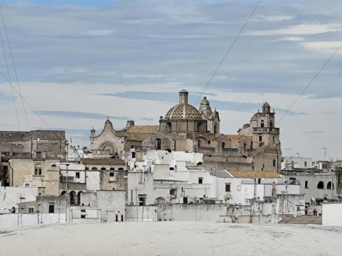 a group of white buildings in front of a castle at Casa Mirabilis 44 in Ostuni