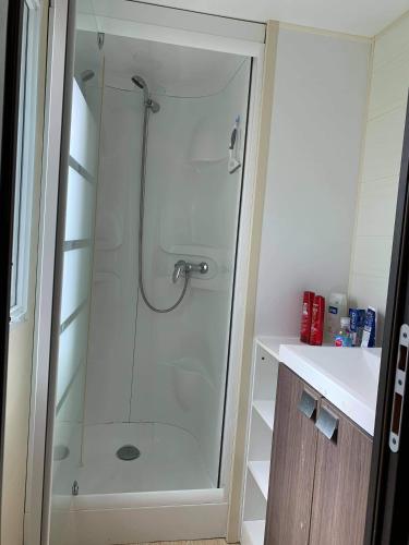 une douche avec une porte vitrée dans une salle de bain dans l'établissement Camping Marvilla Parks - Aunis Club Vendée, à La Tranche-sur-Mer