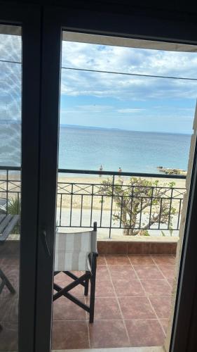 a view of the beach from a balcony with a bench at Petro's House in Nikiti