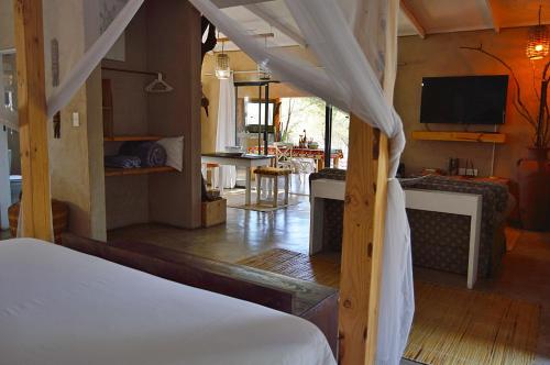 een slaapkamer met een bed en een woonkamer bij Foxy Crocodile Bush Retreat & Kruger Safari's in Marloth Park