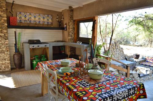 uma mesa com uma toalha de mesa numa sala em Foxy Crocodile Bush Retreat & Kruger Safari's em Marloth Park