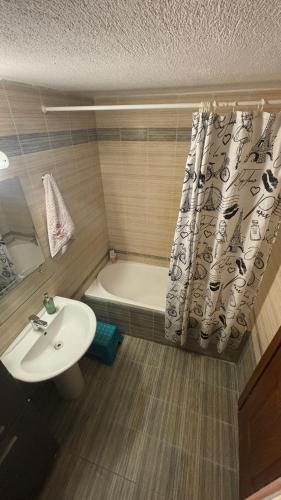 a bathroom with a sink and a tub and a shower curtain at Petro's House in Nikiti