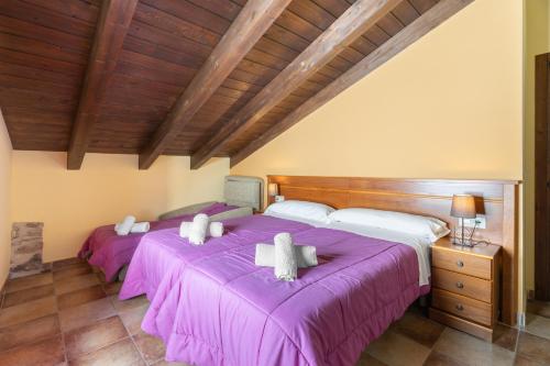 2 camas en una habitación con sábanas moradas en Apartamento Casa El Cojo 2b, en Alcalá de la Selva