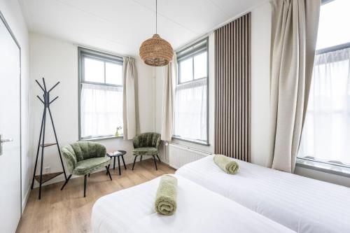 2 camas en una habitación con ventanas en Hotel Over de Brug, en Haastrecht