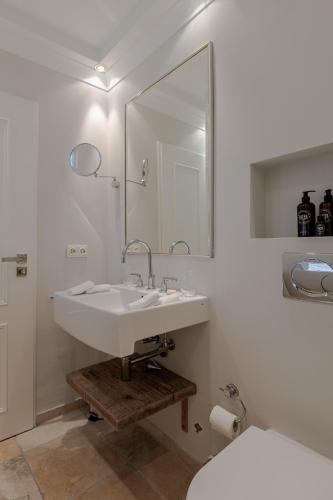 a white bathroom with a sink and a toilet at Strönhof Kampen in Kampen