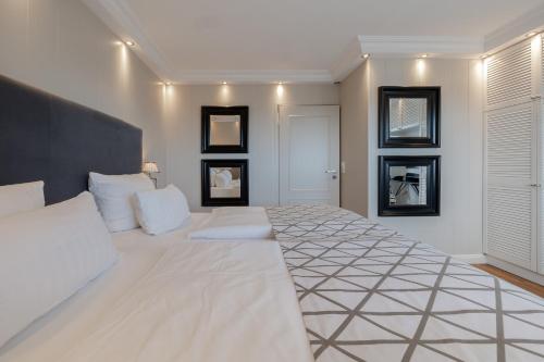 a bedroom with a large white bed with white pillows at Strönhof Kampen in Kampen