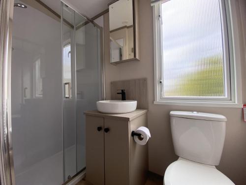 een badkamer met een toilet, een wastafel en een douche bij Linnhe Lochside Holidays in Corpach