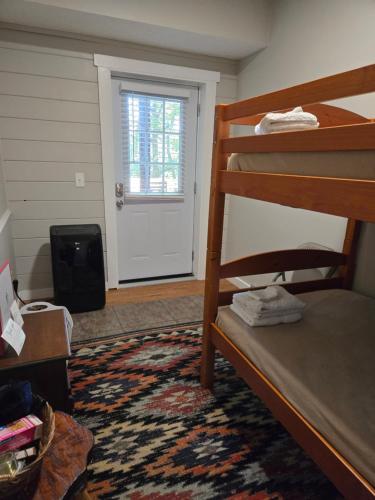 a bedroom with a bunk bed and a door at Barefoot Hills in Dahlonega