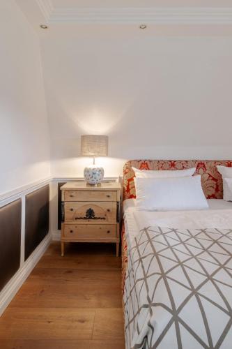 a bedroom with a bed and a nightstand with a lamp at Strönhof Kampen in Kampen