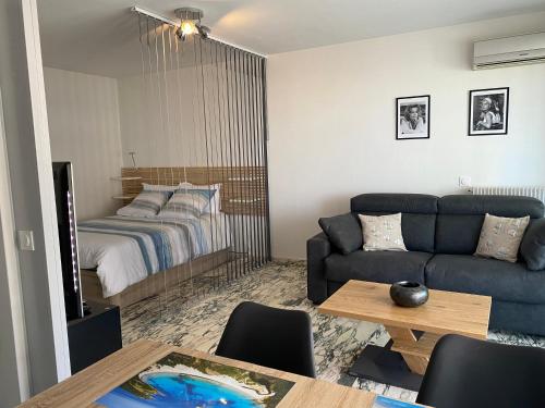 un salon avec un canapé et un lit dans l'établissement Cannes centre Lou Souquetan, à Cannes
