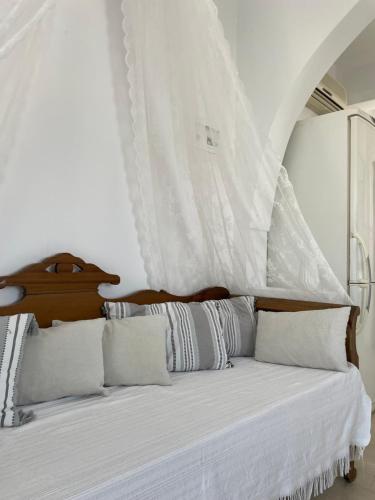 ein Schlafzimmer mit einem Bett und weißen Vorhängen in der Unterkunft Villa Maina in Kamari