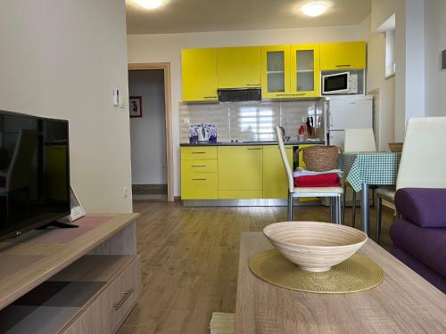 a living room with yellow cabinets and a bowl on a table at Apartments Nevenka i Josko in Tučepi