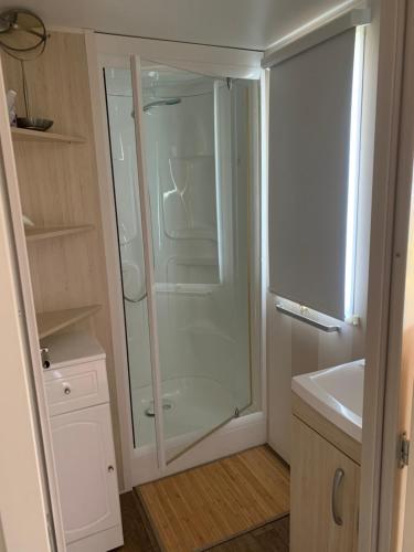 une salle de bain avec douche et lavabo dans l'établissement Mobilhome vue mer grand confort domaine l’île d or, à Saint-Raphaël