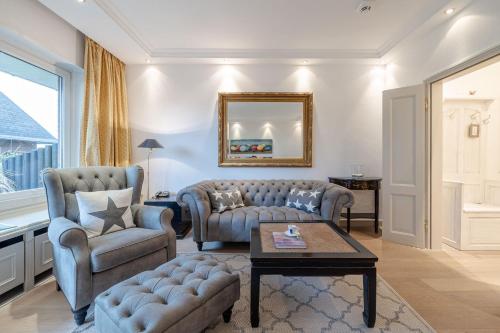 a living room with two chairs and a couch and a table at Strönhof Kampen in Kampen