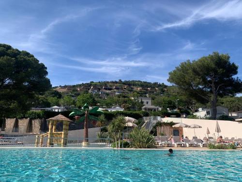 une personne dans l'eau d'une piscine du complexe dans l'établissement Mobilhome vue mer grand confort domaine l’île d or, à Saint-Raphaël