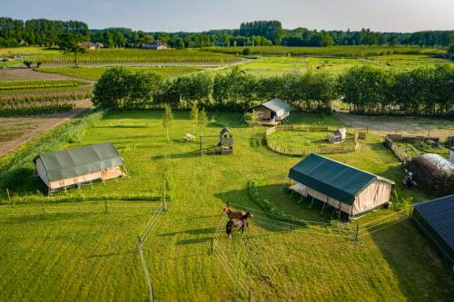 an aerial view of a farm with tents in a field at Glamping Hoeve Klein Haneveld in Sint-Oedenrode