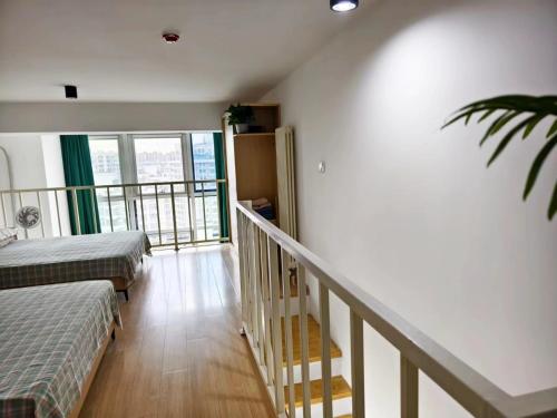 a room with two beds and a staircase with a balcony at Chaoyang Joy City Hardcover Apartment in Beijing