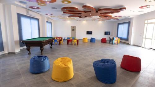 a room with a pool table and some chairs at Oyster Bay Beach in Abu Dabab