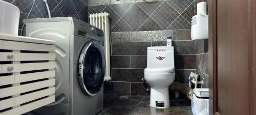 a bathroom with a washing machine and a toilet at Chaoyang Joy City Hardcover Apartment in Beijing