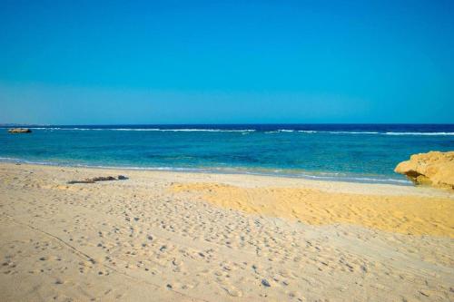 a sandy beach with the ocean in the background at Oyster Bay Beach in Abu Dabab