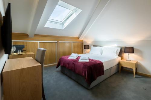 um quarto com uma cama e uma clarabóia em Comtesse Lisbonne Guest House by Homing em Lisboa