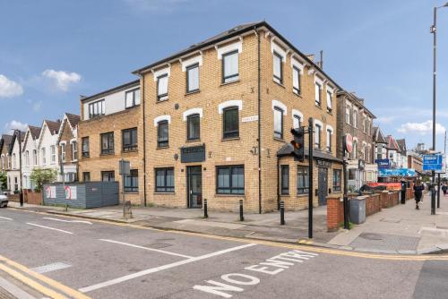 a large brick building on the corner of a street at Green Lanes Studios By Morethanstays in London