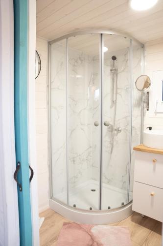 a bathroom with a shower with white marble at Tiny House Le Poulailler in Bousbecque