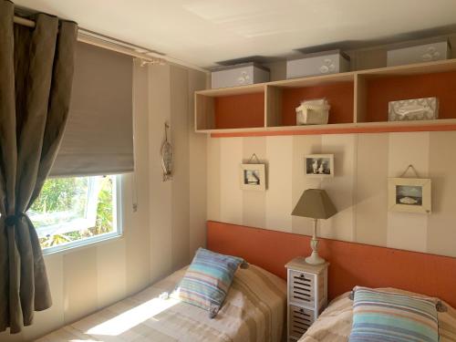 une chambre avec deux lits et une fenêtre dans l'établissement Mobilhome vue mer grand confort domaine l’île d or, à Saint-Raphaël