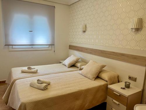 two beds in a room with towels on them at PENSION NAVAS in El Cabo de Gata