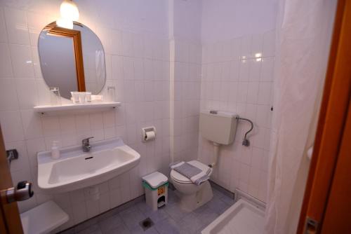 a bathroom with a sink and a toilet and a mirror at Aristotelis Hotel in Stavros
