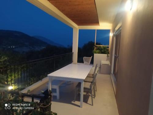 a white table and chairs on a balcony at night at Villa in idyllic quiet nature in Benettáta