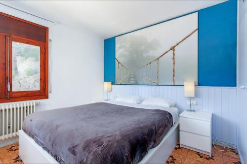 1 dormitorio con 1 cama y una pintura de un puente en Villa Natalia C101, en Lloret de Mar