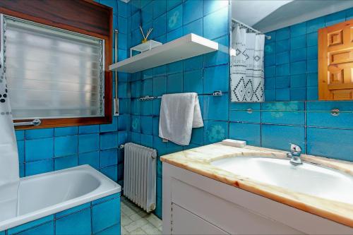 baño de azulejos azules con lavabo y bañera en Villa Natalia C101, en Lloret de Mar