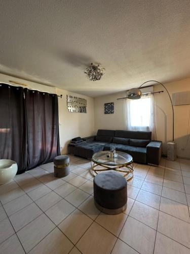 un salon avec un canapé et une table dans l'établissement appartement climatisé, à Avignon